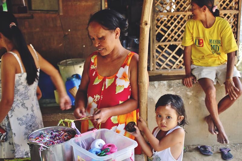 A+Philippino+mother+and+daughter+weave+beautiful+bracelets+for+the+organization+Threads+of+Hope.+