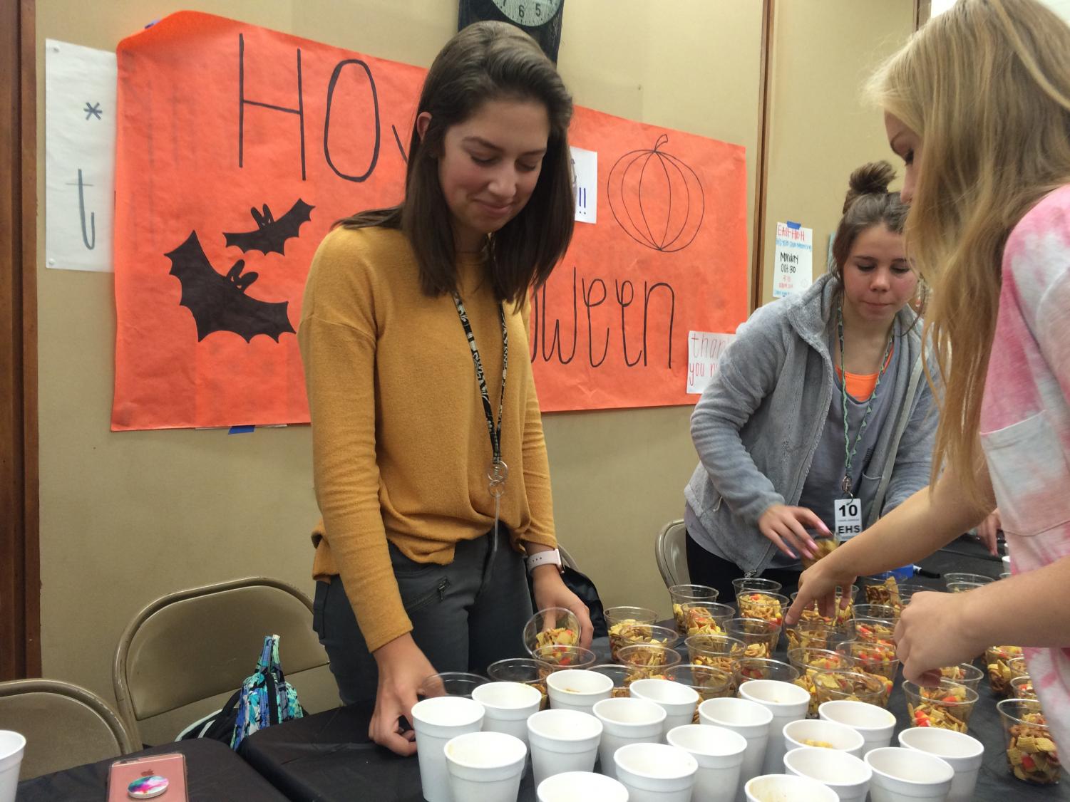Sydni Springer, Vice President-Elect of the Lincoln East HOSA chapter, organizing snacks for HOSA Halloween on October 31, 2017 outside of the cafeteria.