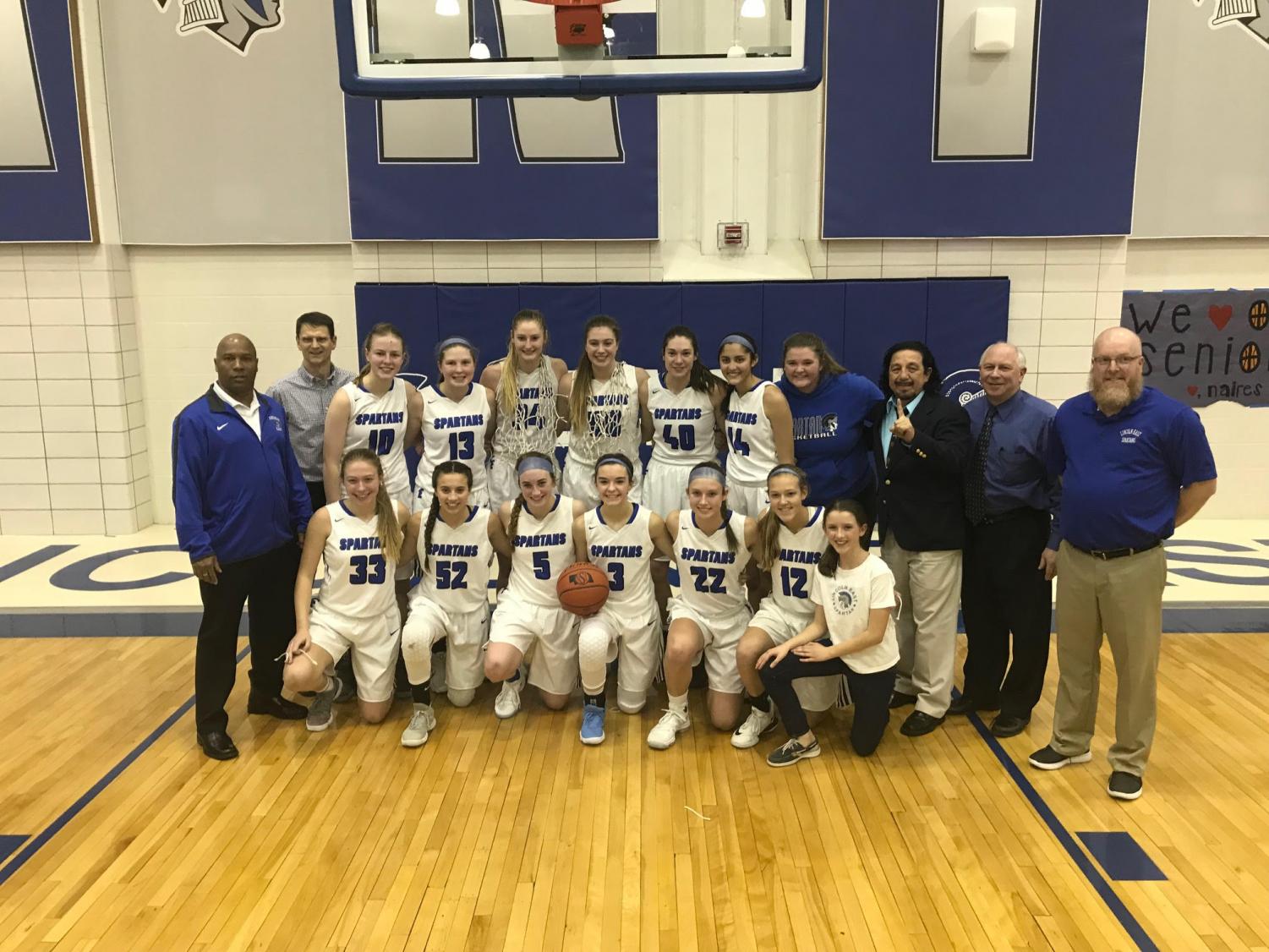 The varsity girls basketball team posses for a picture after winning the A-4 district.