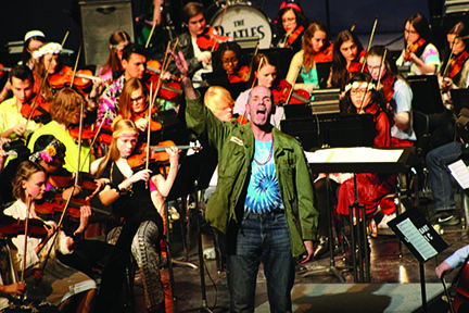 Mr. Whitman leads the audience in singing America The Beautiful along with the orchestra for the concerts finale. Photo by Ann Mai
