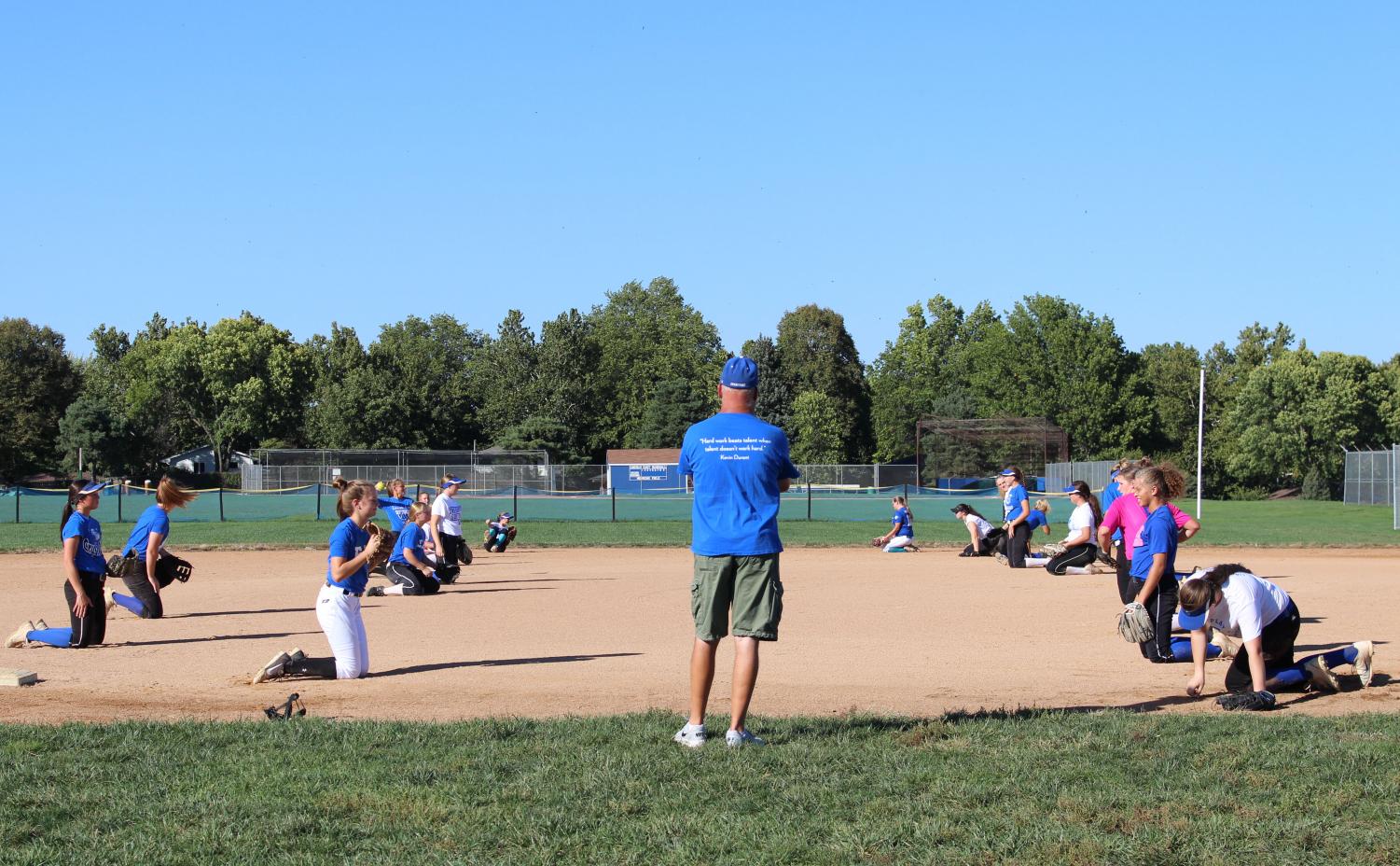 Coach Lance Kingery watches his team warm up at practice before the NSAA District Softball Tournament.