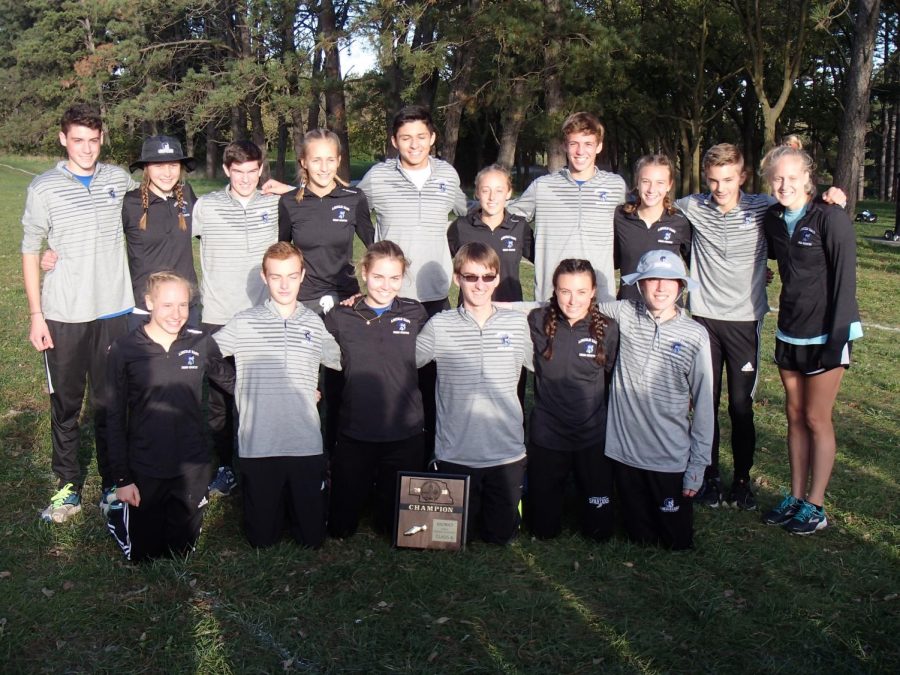 The East varsity runners smile with their district champions plaque, after a successful district meet for the boys and girls alike.