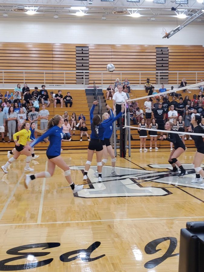 Annalee Ventling-Brown, Julia Holz, and Aleksey Betancur work together to score a point in the first set against Northeast.