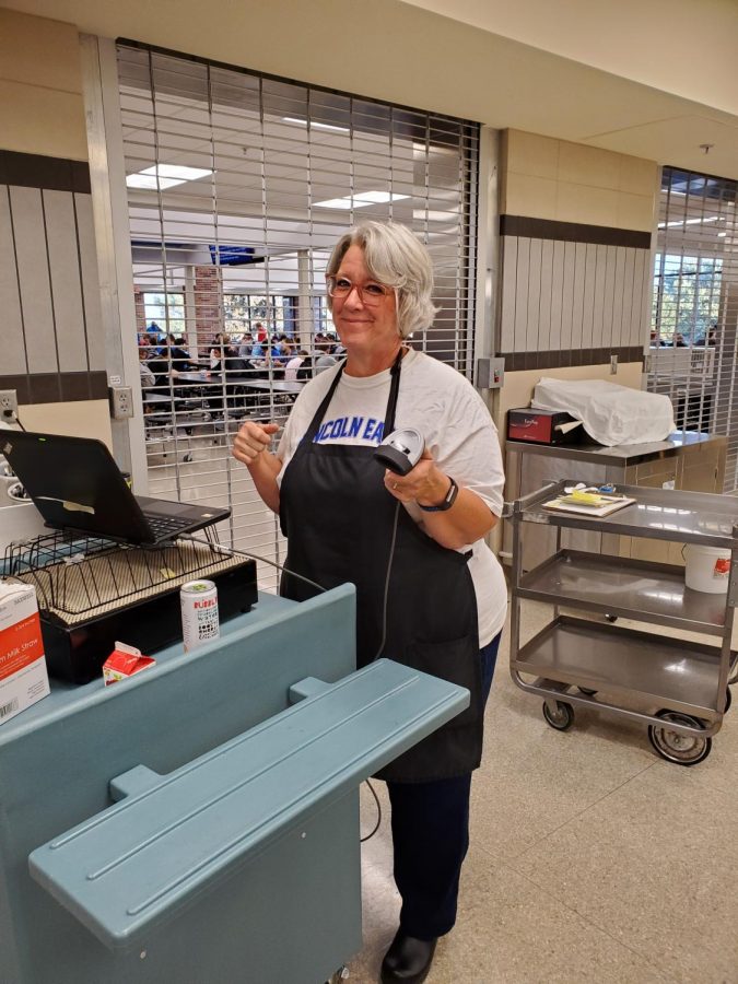 Susan Zander working to serve breakfast to students in the cafeteria before school