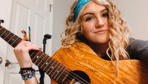 Evy Isom playing her guitar.