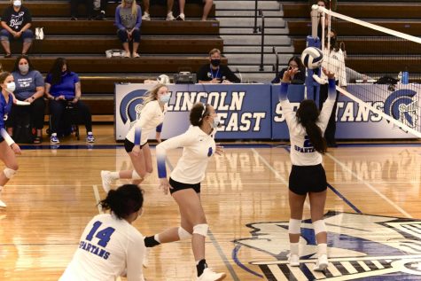 Freshman, Shandy Faalii, setting the volleyball over the net.