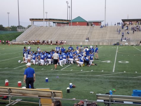 Lincoln Varsity football team huddling after a win against North Platte high school.