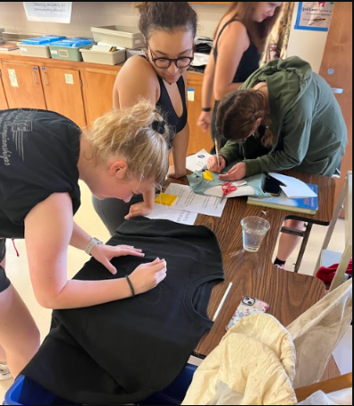 Ella Swank (far left) bleach dyes a t-shirt at a Drama Club meeting focused on costume creation at Lincoln East High School on September 1, 2022.
