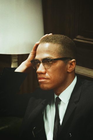 Malcolm X waits at Martin Luther King press conference, head-and-shoulders portrait by Unseen Histories and liscensed under Unsplash.