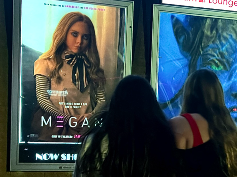 Movie goers Madelin Hansen and Samantha Aguilar walk past the M3GAN film poster outside of East Park Theater in Lincoln NE on Saturday, January 14th, 2023. M3GAN shows us a frightening future, in which robots become childrens toys, through a hilarious and thrilling movie.