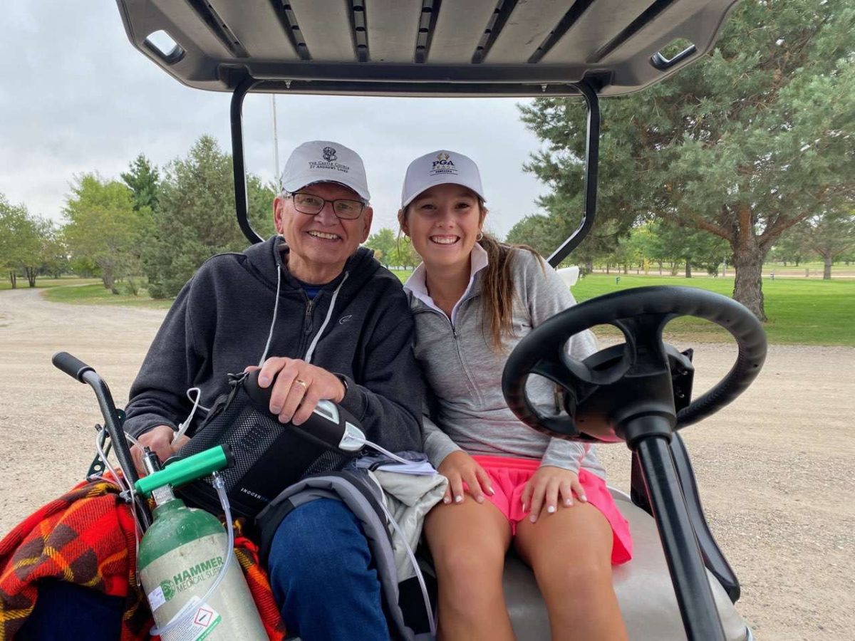 Jerry Christensen and his granddaughter Elly Honnens pose together at a golf course right before a round of golf. Honnens said her grandpa never missed a high school meet before he passed.