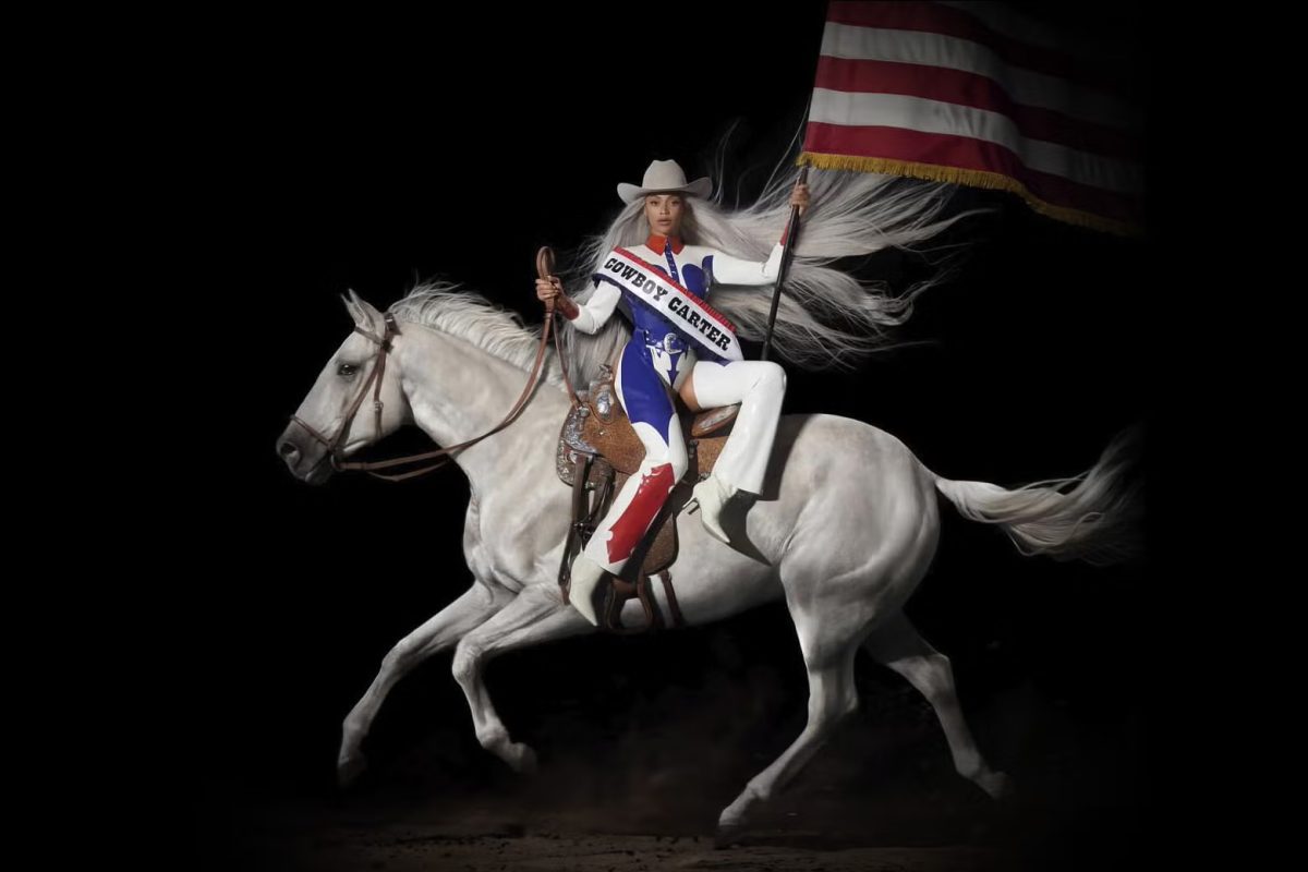 Beyonc%C3%A9%E2%80%99s+%E2%80%9CCowboy+Carter%E2%80%9D+cover+art+pictures+her+riding+a+white+horse+with+an+American+flag.+She+is+pictured+as+a+powerful+figure%2C+and+it+accurately+represents+the+country+genre+that+the+album+has.