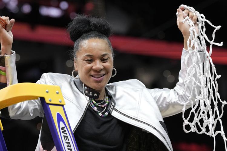 Head coach Dawn Staley holds the net after South Carolinas 87-75 win over Iowa. The womens basketball team maintained an unblemished record in the 2023-2024 season.