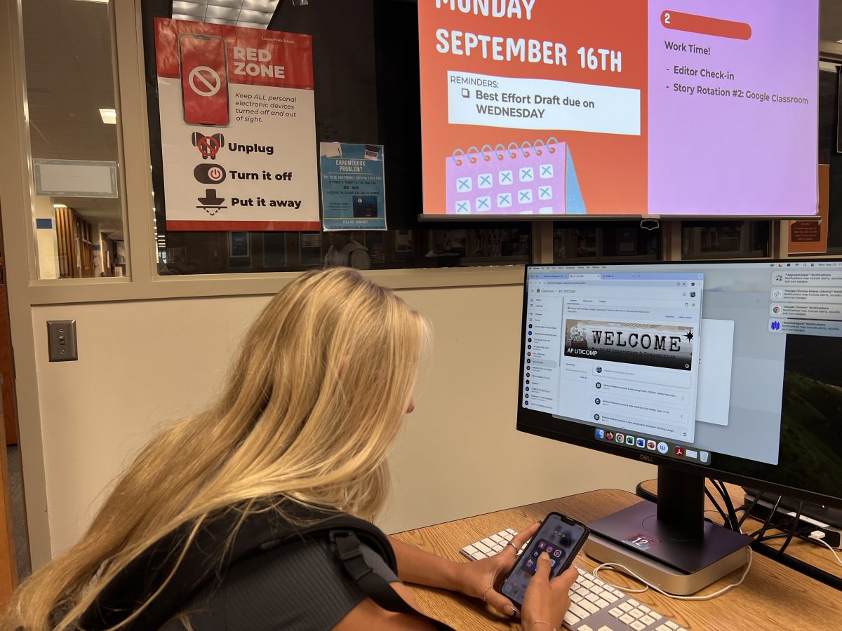 AP Literature student, Ella Herzberg, uses her phone in a 'red zone' during the school day on September 23, 2024. A 'red zone' is an area where personal electronic devices must be turned off and out of sight from the beginning to the end of each class period.