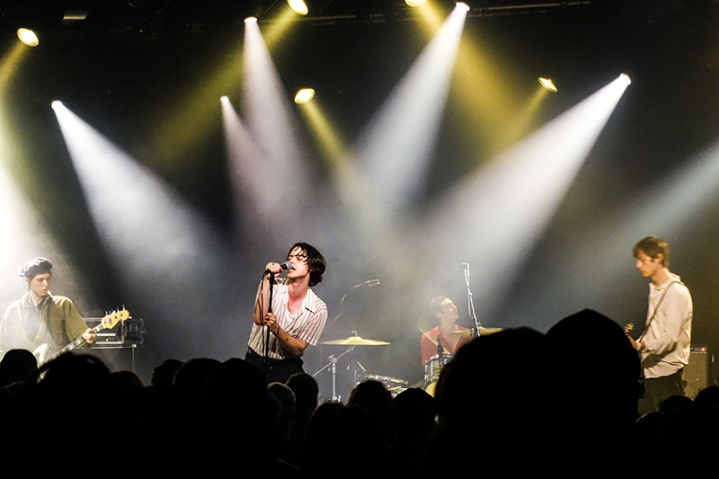 The band Iceage performs on stage for a live audience. They captivated their fans through their unique music and performance style.