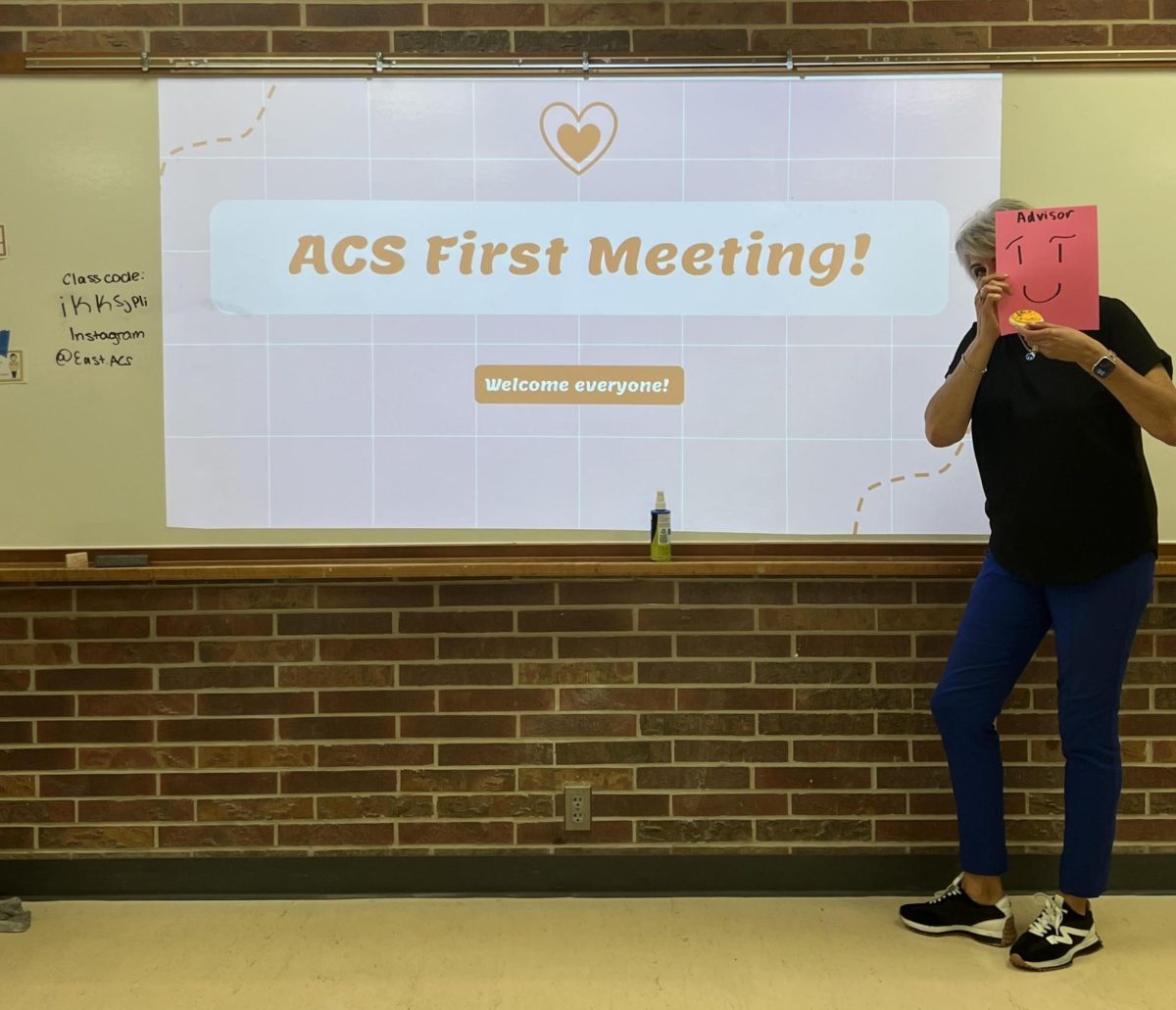 The Lincoln East ACS chapter focuses on spreading cancer awareness and funding money for cancer research. The first meeting was held on 9/4/25, where the club advisor held up a sign and a cookie for a mysterious photo effect.